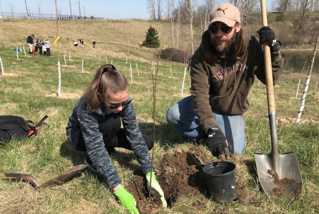 Two people planting trees for a Brant Tree Coalition project.