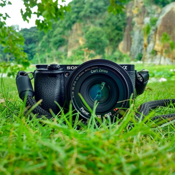 Digital camera sitting in grass.